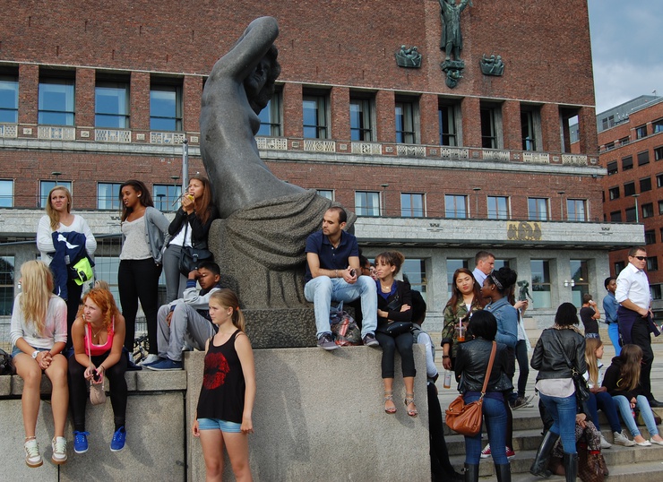 Passersby stop to watch a hip hop concert on the square leading to the ferries