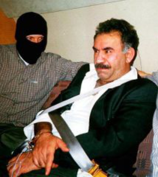 FILE - Abdullah Ocalan, fugitive chief of the Kurdistan Workers Party, PKK , with an unidentified agent of  the Turkish Intelligence  Service, the MIT, which captured him, is seen in this Monday Feb. 15, 1999 file photo, in a aircraft on his way to Turkey